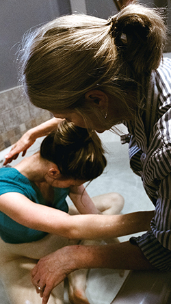 Woman giving birth in a birthing pool