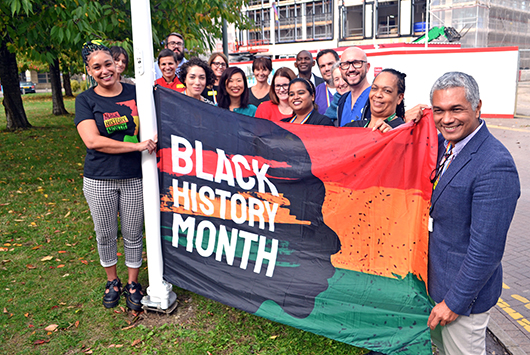 RUH staff raising the Black History Month flag at the main entrance