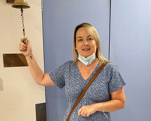 Nyssa Edwards ringing the bell to signify the end of her cancer treatment